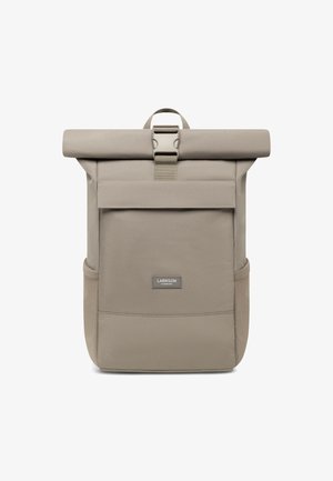 Sac à dos à rabat en tissu beige clair, avec une poche avant, du matériel solide et des poches en mesh latérales pour un rangement supplémentaire.