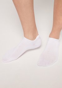 Vita ankelsockor gjorda av tunt, elastiskt tyg, med en sömlös tå och låg skärning, designade för att sitta under ankeln.