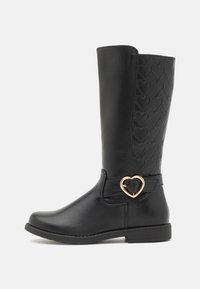 Bottes noires montantes avec un devant lisse et un motif de cœur imprimé à l'arrière, mettant en valeur une boucle dorée en forme de cœur.