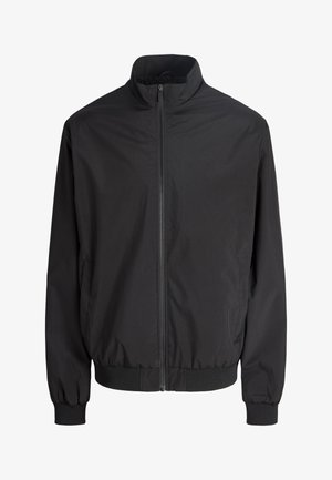 Veste légère noire à fermeture éclair avec col montant, poignets élastiques et ceinture élastique, présentée sur un fond blanc uni.