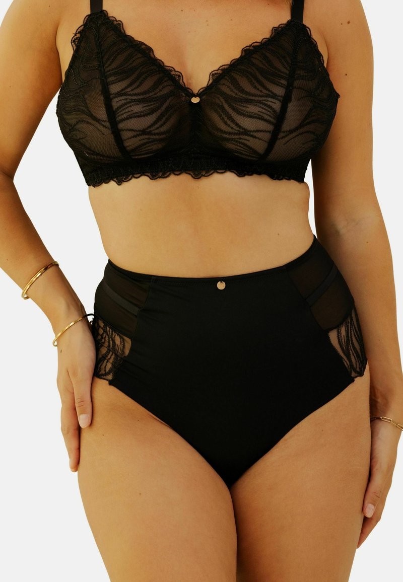 Bralette en dentelle noire avec un bord festonné et un accent doré au centre. Les culottes tailles hautes assorties présentent des panneaux transparents et des détails en dentelle.