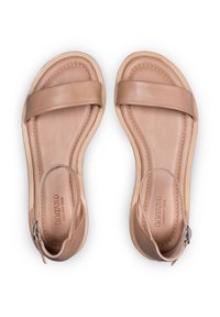 Brązowe skórzane sandały mają dwie szerokie ramiączka oraz regulowane zapięcie wokół kostki z metalowym klamrą. Gładka tekstura i minimalistyczny design.