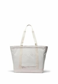 Sac fourre-tout en toile beige avec deux longues anses, poche avant zippée et poches latérales, debout sur fond blanc.