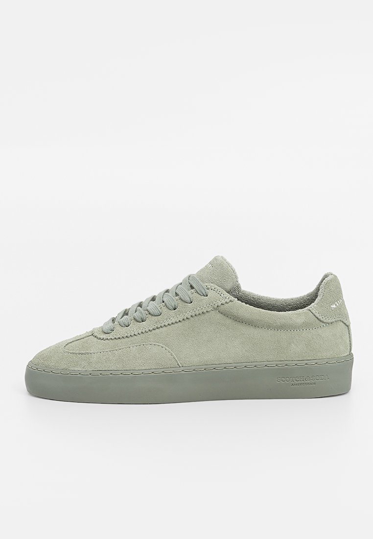 Sneaker en suede vert au design basse-tige, avec des lacets plats, une semelle en caoutchouc et des détails de couture subtils. Pas de marque visible sur l'extérieur.
