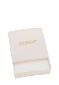 Scatola rettangolare beige chiaro con angoli smussati, con la parola "amor" in oro sul coperchio; l'interno è foderato con un morbido materiale bianco.