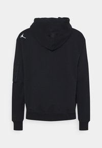 Svart hoodie tillverkad av bomullsrik tyg, med en framficka, ribbade ärmslut, en dragsko huva och en logotyp på axeln.