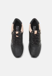 Baskets en cuir noir avec des accents roses, dotées d'un système de laçage, d'une fermeture éclair latérale et d'une surface texturée. Semelle blanche avec un profil plat.