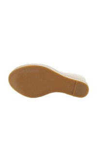 Beige wedge sandal with a textured upper, rubber sole, and rounded toe. Features a smooth surface and a subtle stitch detail along the edge.