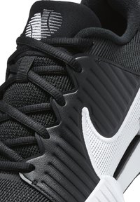 Scarpa sportiva nera con tomaia in mesh, suola in gomma e sovrapposizioni sintetiche texturizzate. Presenta un contrastante baffo bianco e lacci neri.