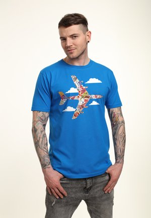 Blå bomulds-t-shirt med et multifarvet flygrafik og hvide skyaffekter. Blød tekstur, crew neck design, korte ærmer.