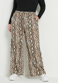 Lepardihousut, jotka näyttävät ruskealta ja mustalta käärmeennahalta, sisältävät joustavan vyötärön ja taskut, ja ne on valmistettu sileästä, kevyestä kankaasta.