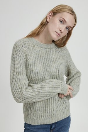 Heller grüner gestrickter Pullover mit Rippenstruktur, Rundhalsausschnitt und weiten Ärmeln, der eine lockere Passform und ein solides, gemütliches Design aufweist.