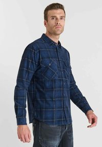 Blauw en marineblauw geruite flanellen shirt met twee borstzakken en lange mouwen, met een button-down kraag en een gestructureerde stof.