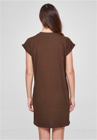 Bruin katoenen jurk met korte opgerolde mouwen, relaxte pasvorm en een ronde zoom. Gladde textuur, minimale details, effen kleur.