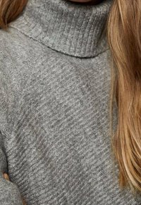 Grauer, gestrickter Rollkragenpullover mit strukturiertem Muster und geripptem Kragen. Weiches Material mit lockerer Passform und Raglanärmeln.