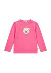 Maglietta a maniche lunghe rosa con spalle a sbuffo, caratterizzata da un'applicazione di una faccia d'orso e dettagli floreali sul petto. Materiale in cotone morbido.