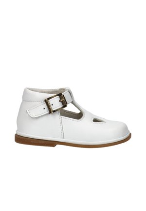 Scarpa per bambini in pelle bianca con cinturino alla caviglia, chiusura con fibbia, dettagli ritagliati e suola in gomma marrone, vista laterale.