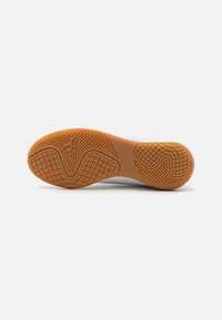 Suola di scarpa sportiva bianca con una suola in gomma testurizzata, dotata di motivi geometrici e un logo impresso al centro.