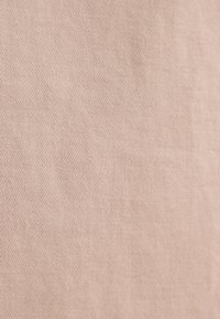 Tessuto beige con una sottile texture a coste diagonali, superficie liscia e senza pattern o dettagli hardware visibili.