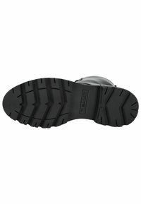 Suela de bota de goma negra con surcos profundos para tracción, con un patrón texturizado y una marca en relieve en el centro.