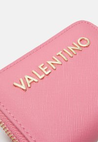 Rozā teksturēts maciņš ar zelta "VALENTINO" logotipu, elegants dizains ar rāvējslēdzēja aizdari, izceļot minimālistisko estētiku un greznības pievilcību.