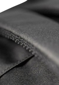 Tissu noir avec une surface texturée et des coutures visibles. Le matériau semble durable et flexible, présentant un gros plan du tissage.