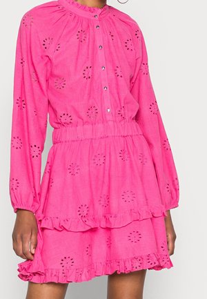 Felroze jurk met lange mouwen, bloemenuitsnijdingen, gerafelde zoom, elastische taille en knoopsluiting aan de voorkant, tot halverwege de dijen bij het model.