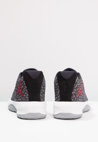 Paire de baskets noires et grises à motifs avec semelles blanches, logos Jumpman rouges et languettes de talon noires numérotées 2 et 3, vues de dos.
