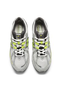 Γκρι αθλητικά παπούτσια με μαύρες και νέον κίτρινες λεπτομέρειες, επάνω μέρος από διχτυωτό υλικό και λευκά κορδόνια. Διαθέτουν επενδυμένη γλώσσα και μαξιλαρωμένο πάτο.