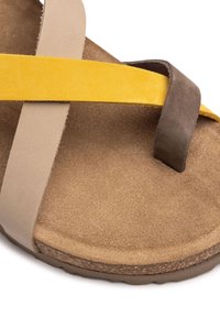 Sandalo in suede con fasce marroni, gialle e beige. Sottopiede morbido con superficie testurizzata. Suola resistente con leggera curvatura per il comfort.