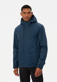 Veste imperméable bleu marine avec capuche, dotée de poches avant, de cordons de serrage ajustables et d'un tissu texturé.