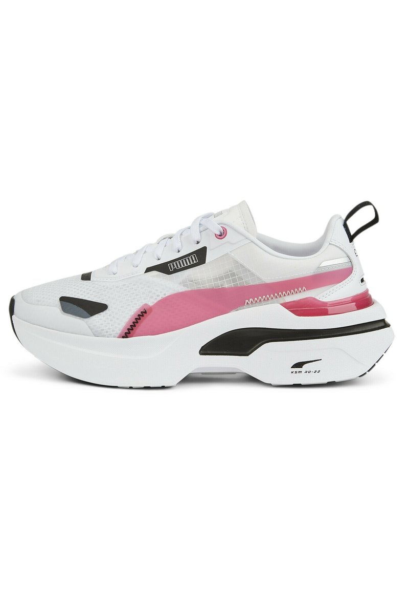 Baskets blanches de sport avec superpositions en mesh et synthétique, ornées d'accents roses et noirs, une semelle épaisse et une languette de traction à l'arrière.