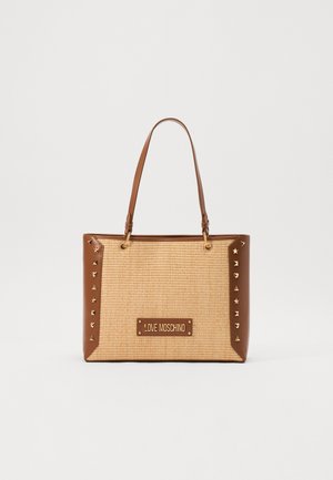 Bolso tote de imitación de cuero marrón y paja trenzada con tachuelas de tono dorado, que presenta una placa de marca en el centro y dobles asas para el hombro.