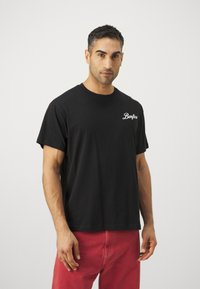 T-shirt noir à manches courtes en coton, avec un logo en script blanc "Benfica" sur la poitrine gauche. Design simple, coupe décontractée.