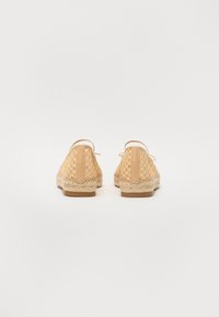 Bežové espadrilky z čipky s tkanou jutovou podrážkou, zaobleným tvarom a nastaviteľnými zadnými popruhmi, pričom majú hladký kožený akcent.