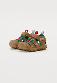 Braune Sandalen für den Außenbereich aus Mesh und Wildleder, mit bunten Schnürsenkeln in Rot, Grün und Blau sowie Zugschlaufen für ein einfaches Anziehen.