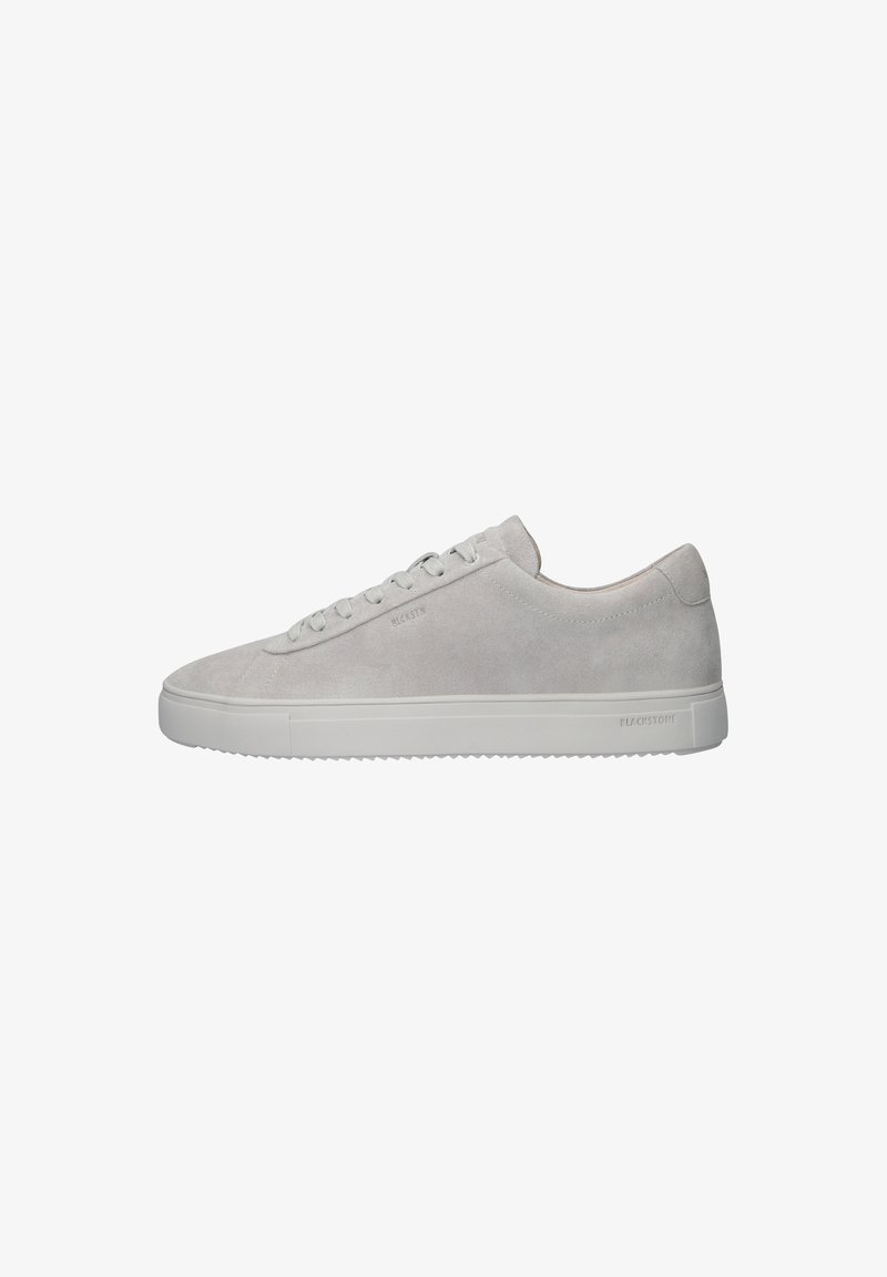 Baskets en suède gris clair au design épuré, avec une semelle en caoutchouc blanc et un branding subtil sur le côté. Six œillets pour les lacets.