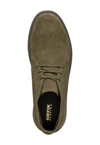 Scarpa verde in suede con punta arrotondata, design con lacci e suola in gomma scura. Branding "GEOX RESPIRA" visibile sulla soletta.