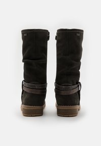 Knæhøje sorte ruskindsstøvler med rund tå, tekstureret brun rem-accent og lav stakhelt. Glat overflade med subtile syninger.
