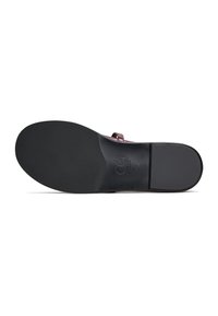 Suela negra de un zapato con un acabado liso, que presenta un logo estampado y un diseño contorneado, que indica soporte ergonómico y estilo.