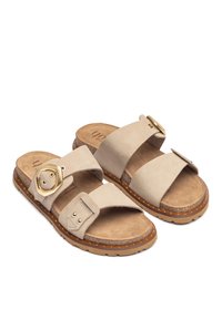 Sandali in pelle beige con due larghe cinghie, un accento decorativo dorato e una soletta imbottita. Suola esterna marrone testurizzata con piccole borchie.
