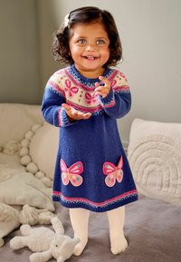 Rochie tricotată în nuanța bleumarin, cu un tors decorat cu fluturi roz, albaștri și albi. Textură moale și mâneci lungi, asortată cu ciorapi albi.