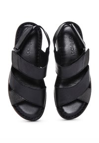 Black leather sandals with crisscross straps and an open toe design. Features a textured finish and stitched detailing along the sole.