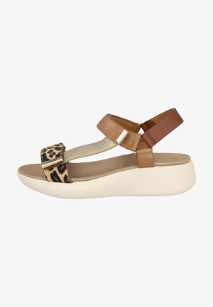 Sandalia beige y marrón con suela blanca gruesa, tira con estampado de leopardo en los dedos y tira ajustable en el tobillo con detalle metálico.