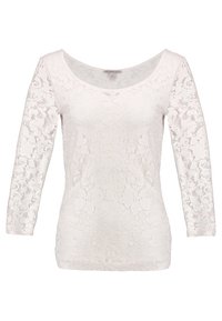 Vit spetsblus med rundad halsringning och trekvartsärmar. Blommönster över hela plagget, strukturerad tyg och figurnära design.