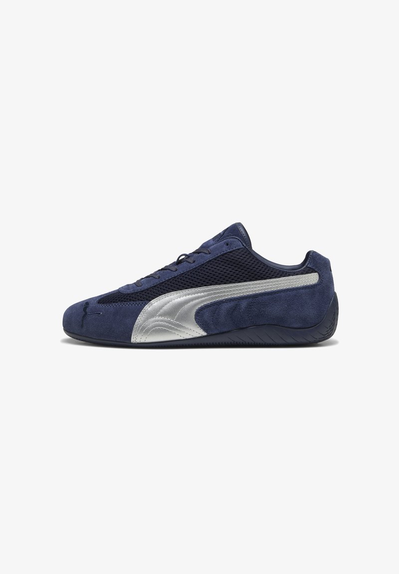 Tengerészkék szövet és hálós sneaker, ezüst oldalsó díszítéssel és texturált gumitalppal. Fűzős dizájn márkajelzéssel.