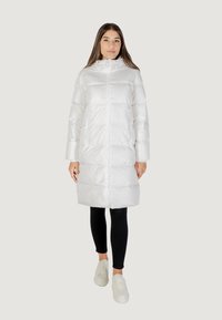 Giacca a vento bianca con cappuccio, dotata di zip frontale, due tasche laterali con zip e maniche lunghe. Materiale liscio e lucido con sezioni trapuntate.