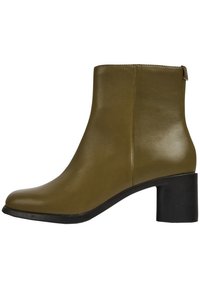 Botín de piel verde oliva con textura suave, puntera redondeada y tacón grueso negro. Presenta un diseño simple y minimalista.