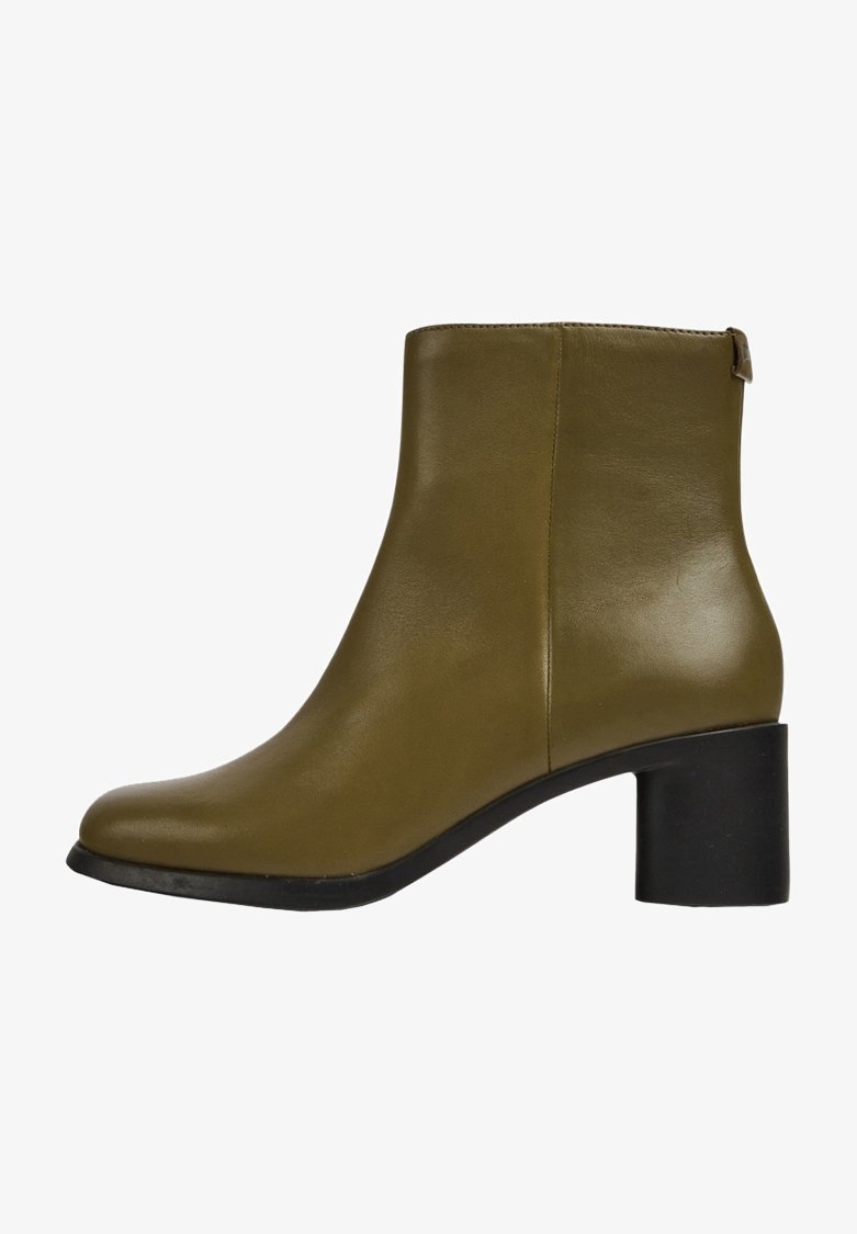 Botín de piel verde oliva con textura suave, puntera redondeada y tacón grueso negro. Presenta un diseño simple y minimalista.