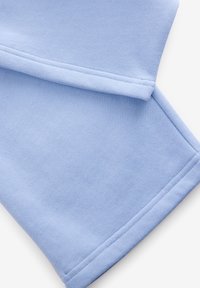 Hellblauer Sweatshirtstoff mit weicher Textur. Verfügt über glatte Nähte und einen umgeschlagenen Bündchenabschluss, der ein entspanntes Design bietet.